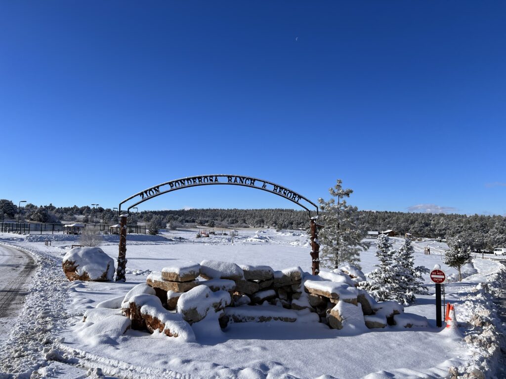 A snow-covered ranch entrance under a clear blue sky.